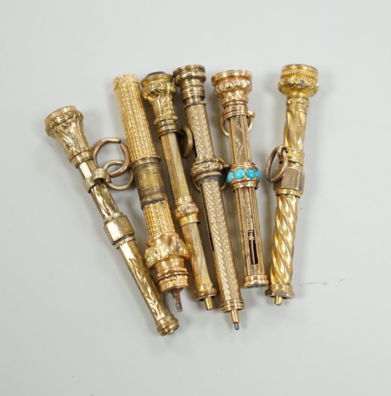 Six assorted late 19th/early 20th century yellow metal overlaid propelling pencils, including turquoise set, 38mm and bloodstone set.